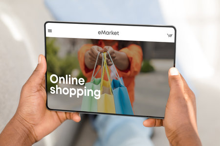 Man shopping online via digital tablet, choosing new clothes at store, sitting at home, enjoying mobile app, closeupの写真素材
