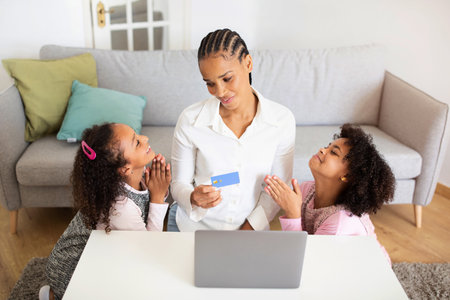 Black Daughters And Mom Shopping With Laptop Together At Homeの写真素材