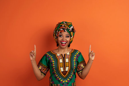 Emotional african lady pointing up at copy spaceの写真素材