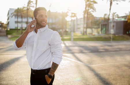 Happy confident european businessman talking on cellphone outdoors, looking back at free space and smilingの写真素材