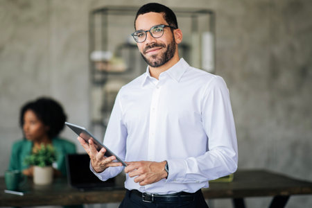Portrait Of Young Middle Eastern Businessman With Tablet In Office