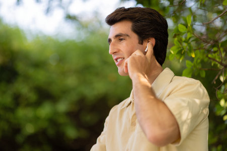 Closeup of handsome young man touching his wireless earphone
