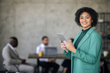 Happy African American Businesswoman Using Digital Tablet In Modern Officeの写真素材