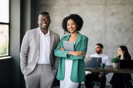 Happy Couple Of Black Coworkers Posing At Modern Office Interiorの写真素材