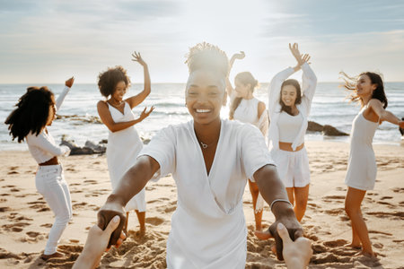 Diverse group of happy young female friends having fun outdoors on the beach, women celebrating hen partyの写真素材