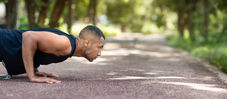 Serious strong african american man standing in plank position at park at morning, profile, panorama