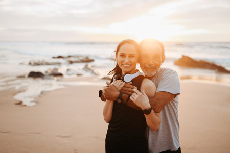 Glad senior caucasia man in sportswear hugs lady in headphones, enjoy training and active lifestyle