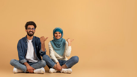Great Offer. Muslim Couple Pointing Aside At Copy Space With Thumbs Upの写真素材