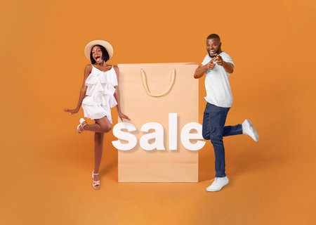 African Buyers Posing Near Huge Shopping Bags On Orange Backgroundの写真素材