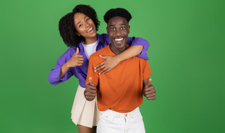 Cheerful young african american woman hugging guy in casual, have fun, enjoy spare time, show thumb...