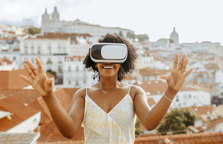 Happy millennial african american woman in vr glasses in city, enjoy summer travel and online gameの写真素材