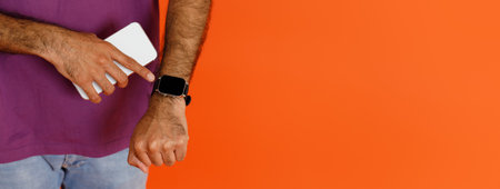 Unrecognizable dark-skinned man using application on smartphone and smart watchの写真素材