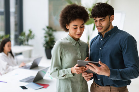 Arabic Businessman And African Colleague Using Digital Tablet In Officeの写真素材