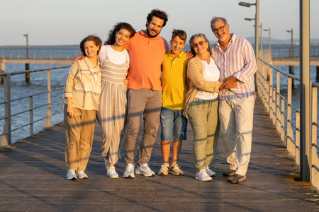 Cheerful caucasian multi-generation people hugging, rest enjoy walk on sea pier beachの写真素材