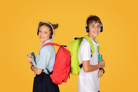Cheerful smart caucasian teenager girl and boy schoolchildren with books, backpacks in wireless...