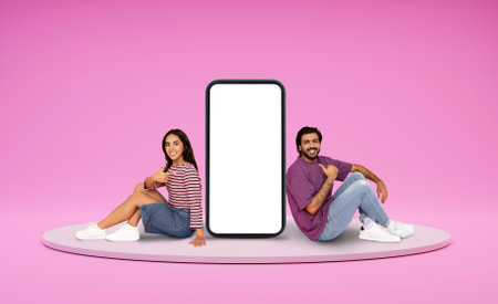Relaxed indian lovers chilling on platform next to huge phone