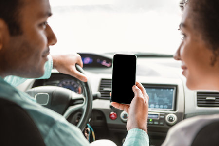 Arab Spouses Using Travel App on Phone During Car Rideの写真素材