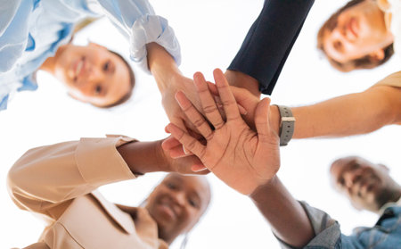 Happy multiethnic young friends holding hands together