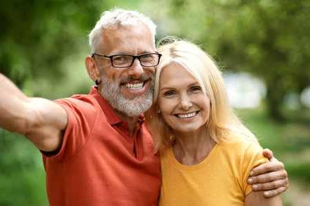 Happy mature spouses taking selfie together outdoors, closeup shotの写真素材