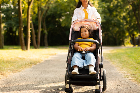 Asian Toddler Seated in Stroller Enjoying Walk With Mommy Outside