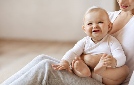 Closeup of smiling cute infant baby sitting in mother armsの写真素材