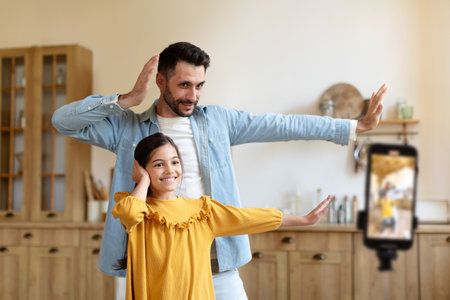 Happy Daughter And Her Daddy Dancing Shooting Video At Homeの写真素材