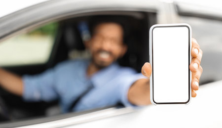 Driver sitting inside car, showing cellphone with blank screen
