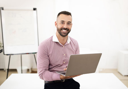 Glad confident attractive caucasian mature man in shirt use laptop in coworking office interior with...