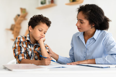 Mom Comforting Unhappy Schoolboy Son Having Issue With Homework Indoorsの写真素材