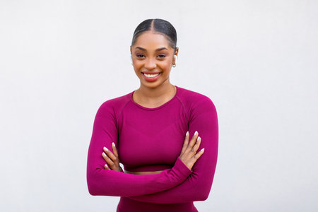 Attractive sportive young black woman in pink sportswear with earbudsの写真素材