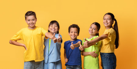 Multiethnic group of kids friends on yellow, showing thumb upの写真素材