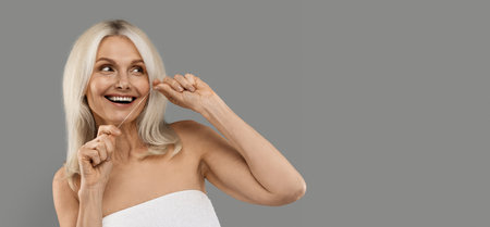 Happy Mature Beautiful Woman Using Dental Floss And Looking At Copy Space