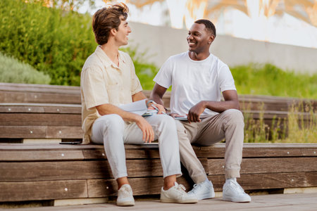 Two young men multiracial students hanging out at university campusの写真素材