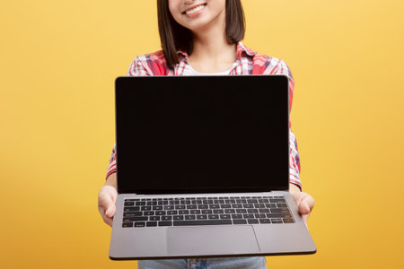 Chinese lady holding laptop with black blank screen in her hands, demonstrating new website design,...