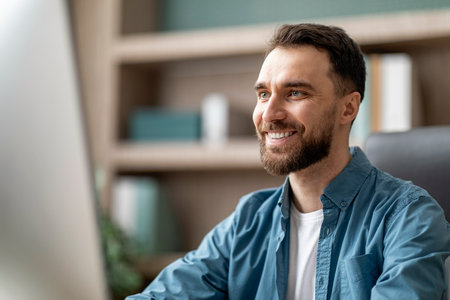 Portrait Of Smiling Handsome Businessman Working On Computer In Officeの写真素材
