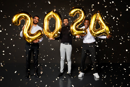 Happy multiracial young guys celebrating new year 2024 on blackの写真素材