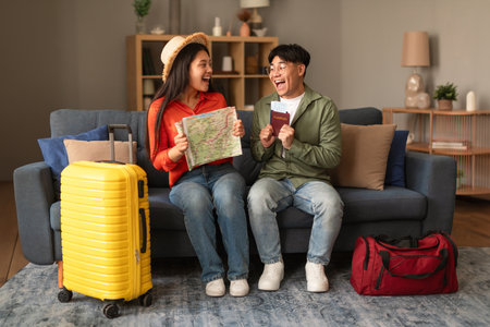 Excited Korean Tourists Couple Holding Travel Map And Tickets Indoorsの写真素材