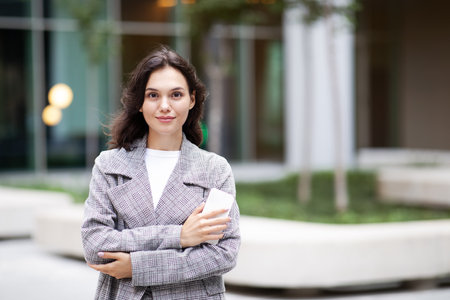 Portrait Of Young Business Lady Holding Smartphone In Urban Areaの写真素材