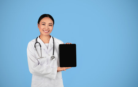 Medical App. Asian Female Doctor Showing Digital Tablet With Blank Blank Screenの写真素材