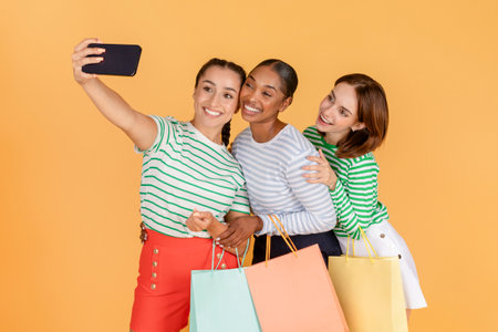 Cute pretty young multiracial ladies taking selfie while shoppingの写真素材