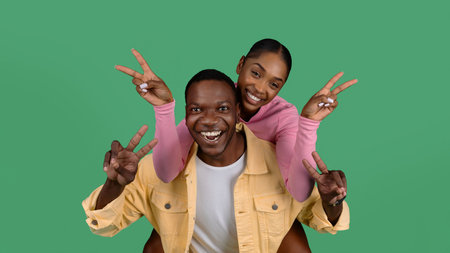 Portrait of happy young black couple gesturing on green backgroundの写真素材