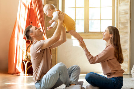 Happy Parents Having Fun With Their Adorable Toddler Son At Home