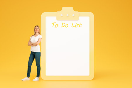 Cheerful confident adult european lady with crossed arms on chest near big plan with free space, do it listの写真素材