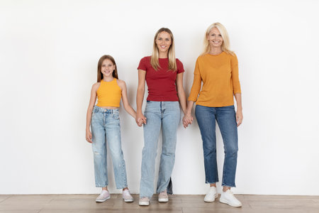 Beautiful women three generations of family posing on white background