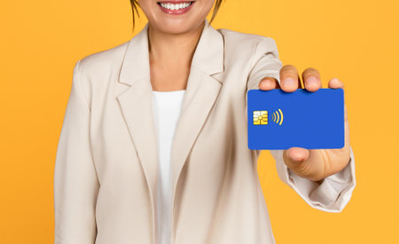 Glad young asian woman in suit shows credit card, recommend profit, savings