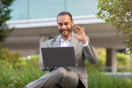 Teleconference Concept. Handsome Young Businessman Making Video Call With Laptop Outdoorsの写真素材