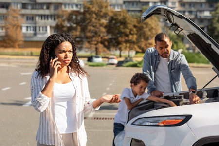 Black woman calling car service, travelling with family by auto