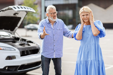 Senior couple fighting on road, have problems with carの写真素材