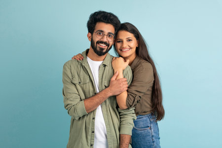 Portrait of happy young eastern couple embracing on blueの写真素材