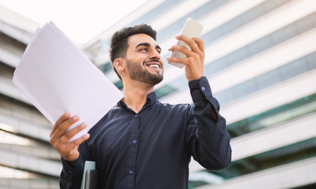 Middle eastern businessman talking holding phone accessing voice assistant application